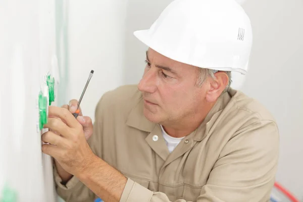 Electricista instalando zócalo en casa nueva — Foto de Stock