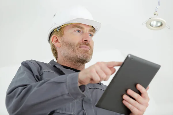 使用平板电脑使用硬帽的男性工人 — 图库照片
