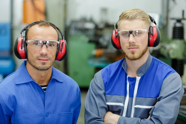 Portret van 2 monteurs aan het werk in zijn garage — Stockfoto