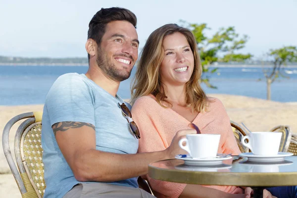 Glückliches Paar auf einer Terrasse am Strand — Stockfoto