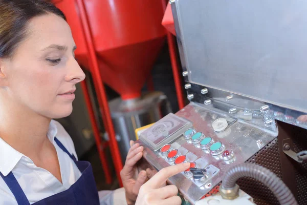 Trabalhador feminino usando a máquina na fábrica — Fotografia de Stock