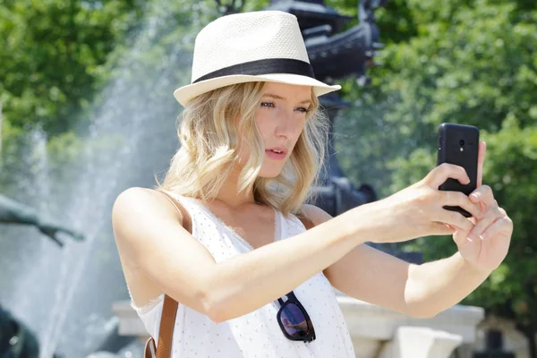 Mulher tomando selfie na frente da fonte — Fotografia de Stock