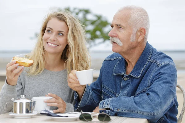 Vader met dochter lunchen aan zee — Stockfoto