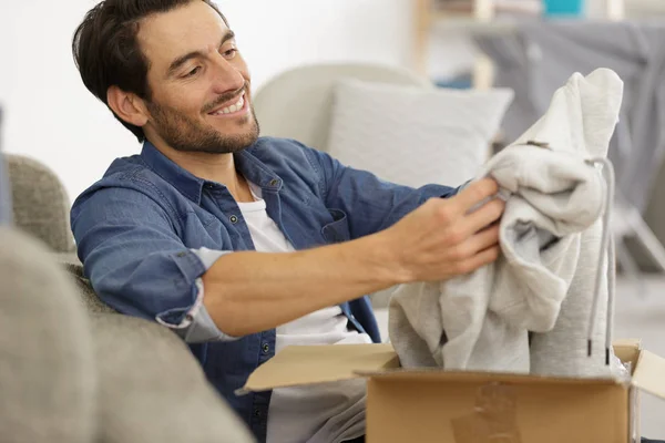 Happy man opening a parcel — Stock Photo, Image