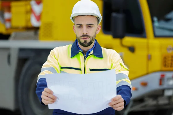 Ingeniero hombre usando casco de seguridad y mantenga documento plano —  Fotos de Stock