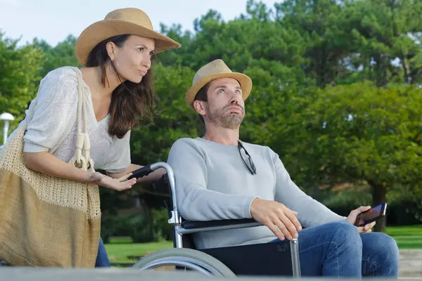 Couple expressif sur la promenade dans le parc homme en fauteuil roulant — Photo