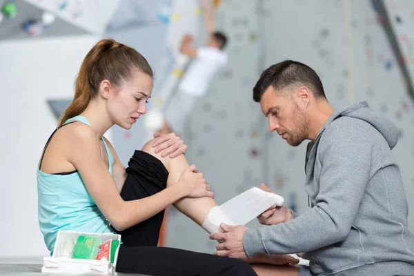 Bir spor merkezinde bir bacak yaralanması bandaj ilk-aider bandaj — Stok fotoğraf