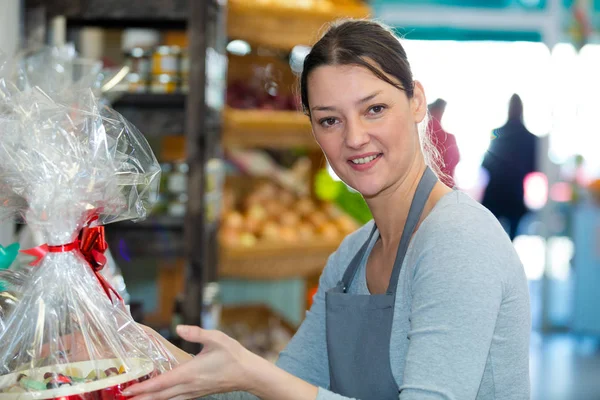 Χαμογελαστή κοπέλα πουλώντας τάρτες και γλυκά ζαχαροπλαστικής στο κατάστημα — Φωτογραφία Αρχείου