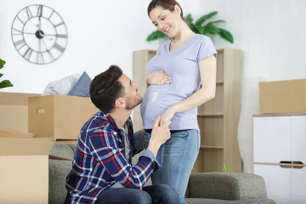 Man embracing pregnant wife in new flat — Stock Photo, Image