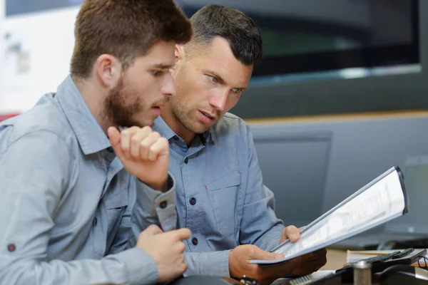 Two men reading and discussing papers — Stock Photo, Image