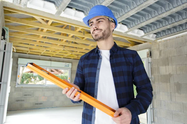 Low angle view of builder holding spirit level — Stock Photo, Image