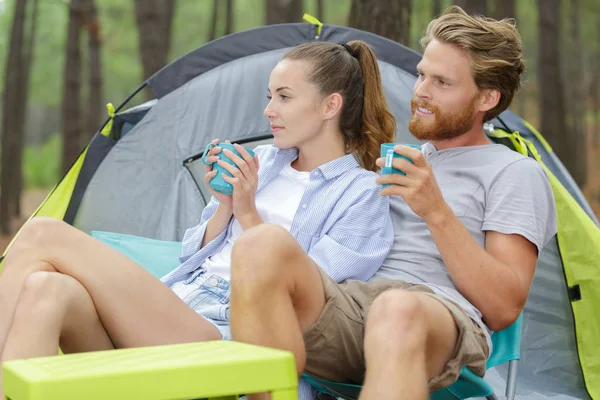 Jovem casal sentado fora de sua tenda — Fotografia de Stock