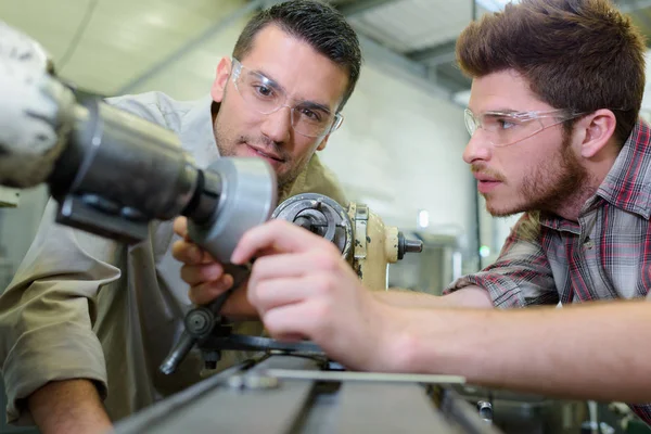 Apprenti au moyen d'une perceuse circulaire — Photo