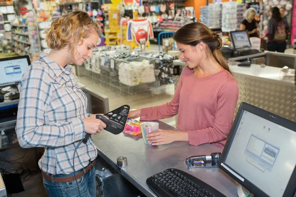 Vrouw accepteren credit card van jonge vrouw in supermarkt — Stockfoto