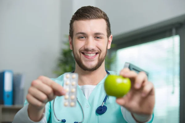 Doctor with apple on a light background — Stock Photo, Image