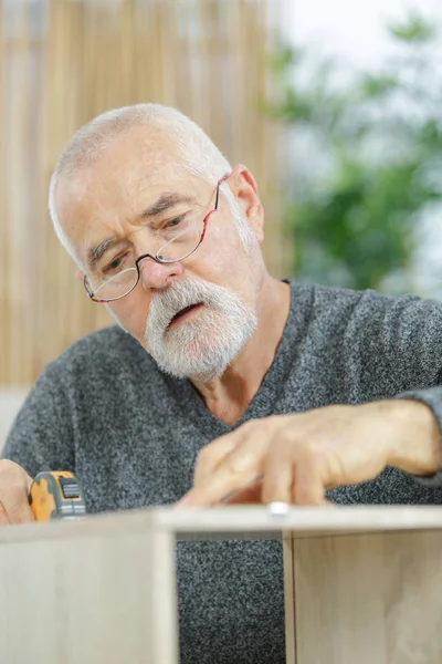 Fröhlicher Senior macht Diy — Stockfoto