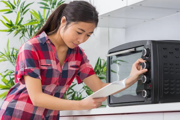 Mujer con cocina nueva y manual de instrucciones —  Fotos de Stock