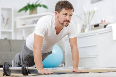 healthy man doing side plank exercise on a mat clipart