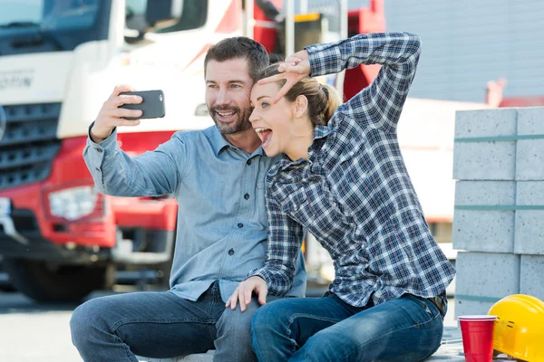 Uomo e donna sorridenti che si fanno un selfie con lo smartphone — Foto Stock