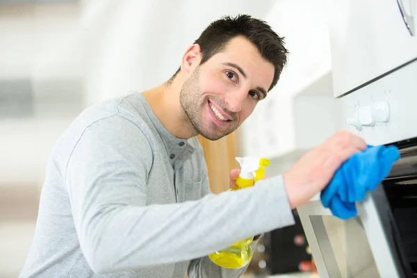 Happy man cleaning oven — Stock Photo, Image