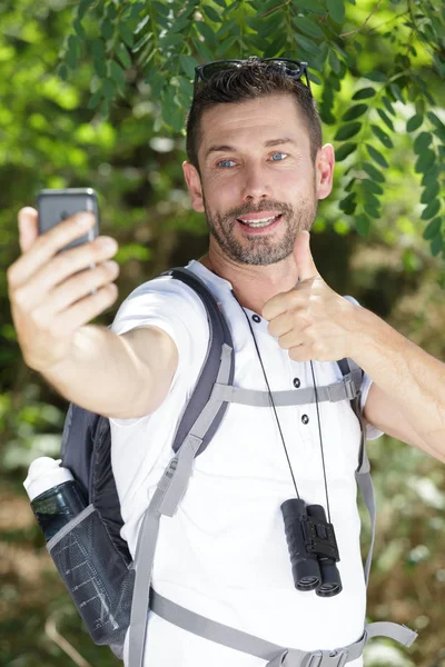 Χαμογελαστός πεζοπόρος παίρνοντας μια selfie στο μεγάλο ύπαιθρο — Φωτογραφία Αρχείου