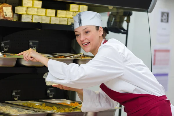 Trabajadora buffet que atiende comida en cafetería —  Fotos de Stock