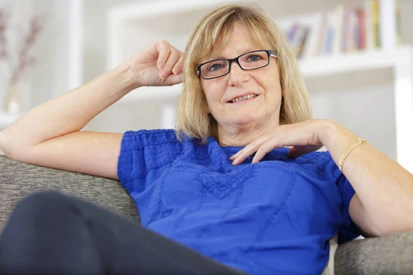 Retrato de mulher madura loira relaxando no sofá — Fotografia de Stock