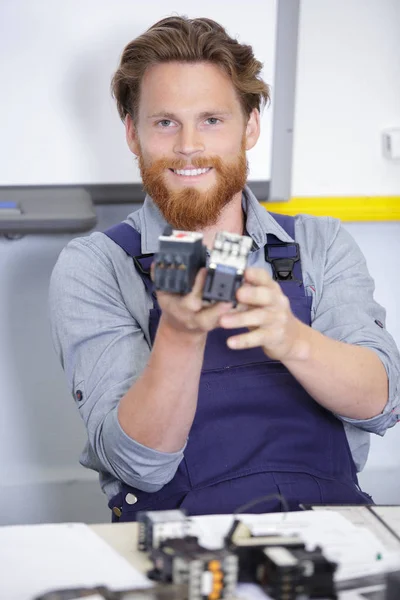 Trabajador masculino feliz con componentes en fábrica — Foto de Stock