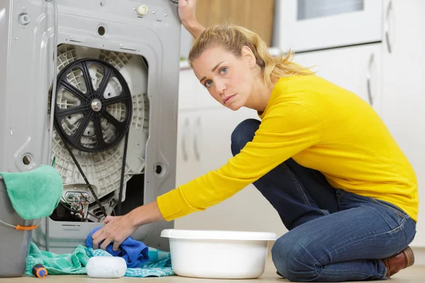 Young woman squeezing water in bucket — Stock Photo, Image