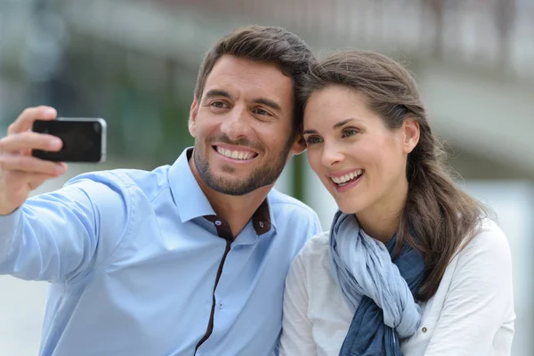 Portret dwóch szczęśliwych kochanków robiących selfie na smartfonie — Zdjęcie stockowe