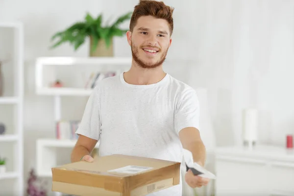 Befriare ge paket låda till ung man — Stockfoto