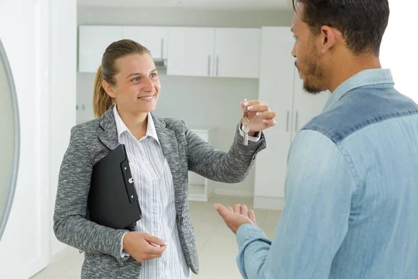 Real estate agent giving keys to male custoler — Stock Photo, Image