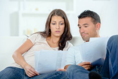 Worried couple looking at paperwork clipart