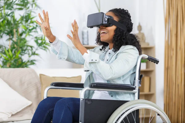 Lycklig kvinna i rullstol med VR-glasögon på kontoret — Stockfoto