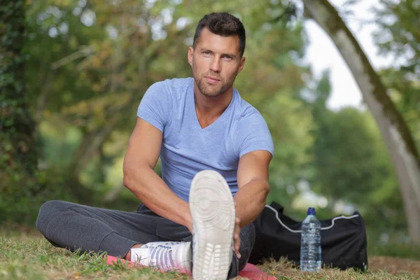 Man stretching before running on a forest trail — Stock Photo, Image