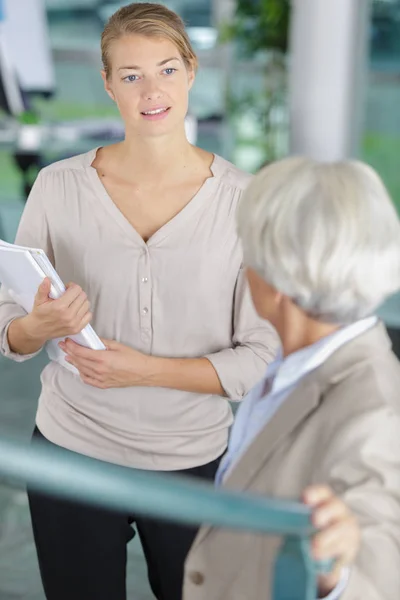 Mujer de negocios joven y mayor teniendo una conversación —  Fotos de Stock