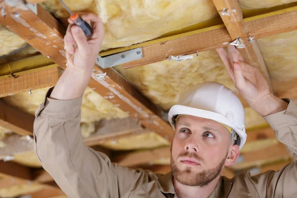 Man pulling to the ceiling in repair loft apartment — Stock Photo, Image