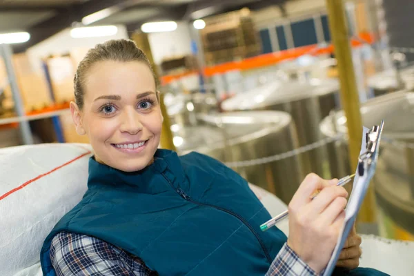 Female worker holding clipboard and posing — Stock Photo, Image