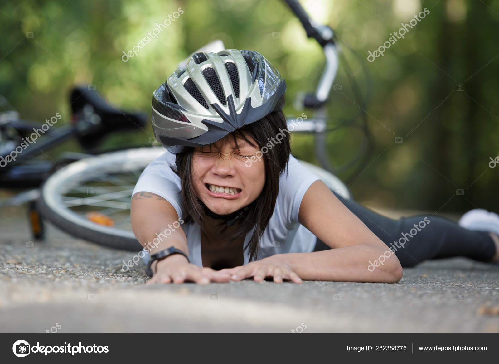 Young woman with pain when falling down off her bicycle — Stock