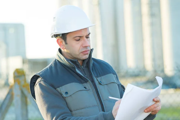 Homme au casque avec des documents — Photo