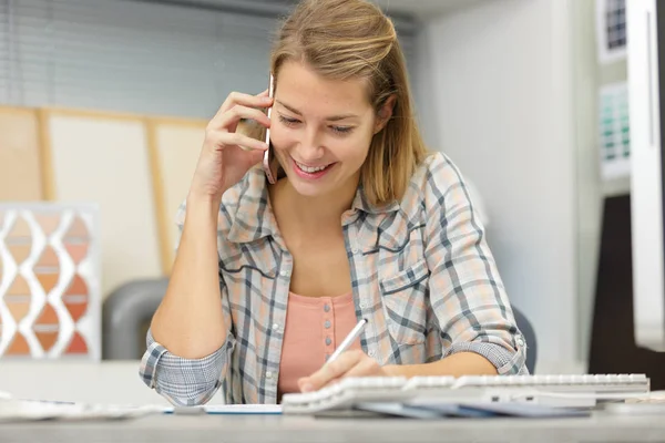 Affärskvinna pratar på en mobiltelefon på kontoret — Stockfoto