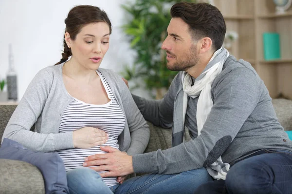 Manžel, který pozoruje neohrabaný těhotnou ženu — Stock fotografie