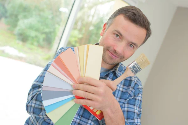 Pintor segurando uma cartela de cores e pincel — Fotografia de Stock