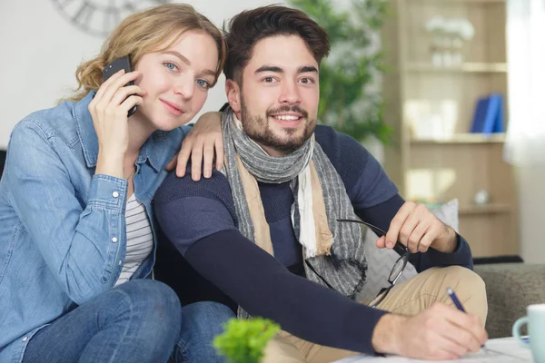 Ragazza utilizzando smartphone e fidanzato prende appunti — Foto Stock