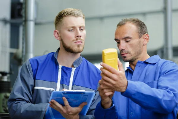 Arbeiter zeigt dem Vorgesetzten Voltmeter — Stockfoto