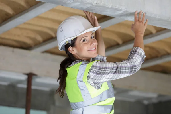 Kvinna som håller kablar ovanför i takutrymmet — Stockfoto