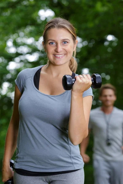 Joven hermosa mujer con una mancuerna en al aire libre — Foto de Stock