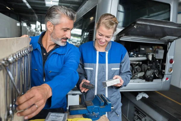 Man and woman auto mechanics in a car workshop — Stock Photo, Image