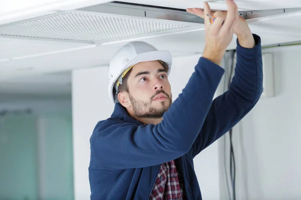 Bauunternehmer ersetzt Deckenplatte — Stockfoto