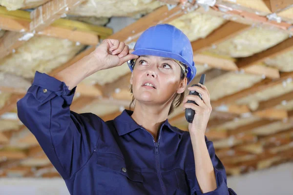 Mujer constructora usando un walkie-talkie en el sitio de construcción —  Fotos de Stock